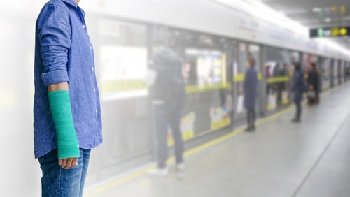 Injury woman with green cast on hand and arm on motion blur in the subway station