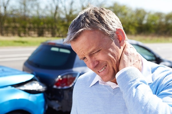 image of a man holding his sore neck after an accident