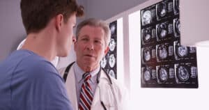 Doctor showing young man his brain x-rays after brain injury to build a legal case and seek justice