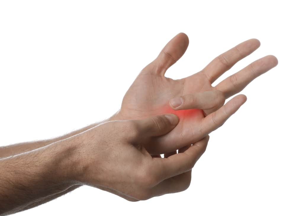 Man with trigger finger injury holds his injured hand, experiencing some pain following a workplace accident.