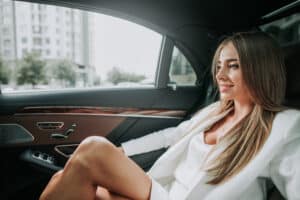 Woman in the backseat of a car while using a rideshare service and in need of liability info in case of a crash