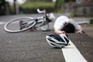 Cyclist laying on the road after a hit-and-run accident with no one to help him, and no car in site.