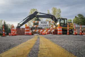 Road work and detour signs on a road closure to help direct traffic in a construction zone.